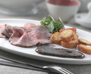 Rosbif  con patatas y ensalada. Roast beef with potatoes and salad.