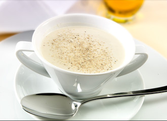 Vichyssoise  en taza con cuchara sobre mesa. Vichyssoise in cup with spoon on table.
