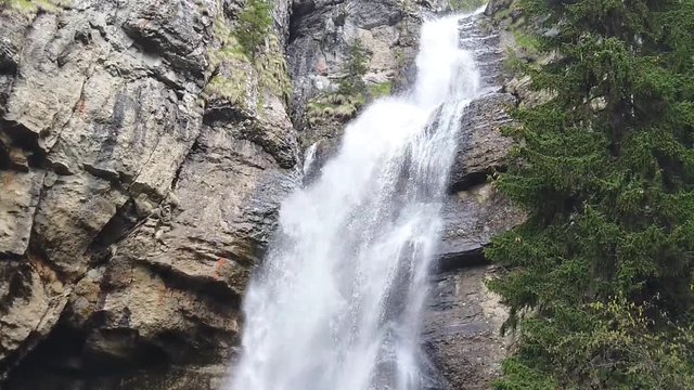 Spring time waterfall in the Carpathian mountains, Romania, formed after the snow on the peaks has melted  creating powerful water stream , slow motion video