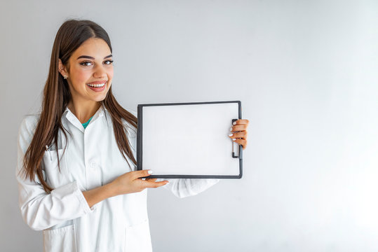 Clipboard with blanc sheet in hands of female doctor isolated. Female doctor in white uniform with stethoscope showing blank clipboard to write it on your personal message or advice.