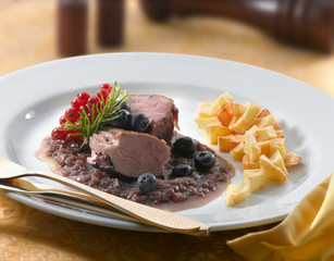 Carne con frutos del bosque y patatas fritas. Meat with berries and chips.