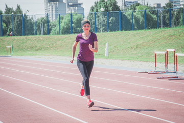Obraz premium Athlete girl doing exercises on the training at stadium