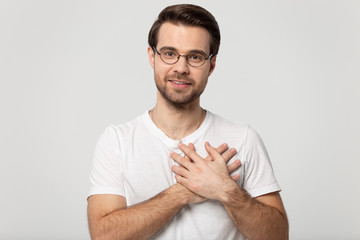Guy holding hands on chest symbol of gratitude studio shot