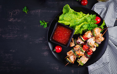 Grilled meat skewers, chicken  shish kebab with zucchini, tomatoes and red onions. Barbecue food. Top view