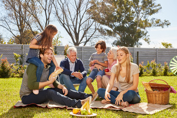 Großfamilie macht Picknick oder Party im Garten