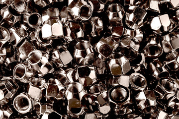 Chromed screw nuts from above. Many screw nuts. Screw nuts of different sizes. background.