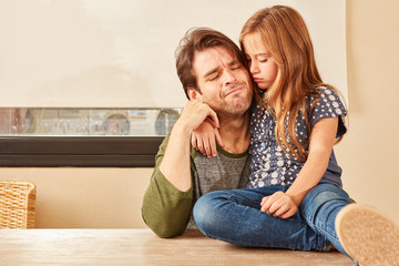 Verzweifelter Vater wird von seiner Tochter getröstet
