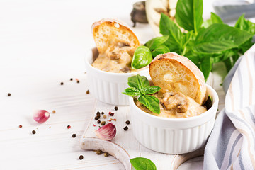 Baked mushroom julienne with chicken, cheese and toast in  pots.