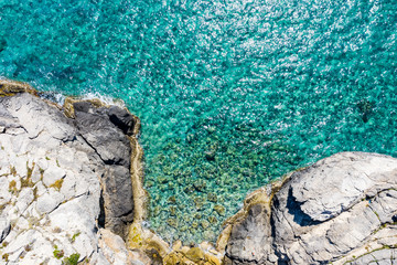 Aerial view of the ocean and beautiful rocks and islands. Summer background of beach, stones seen from above.