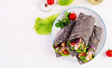 Tortilla with added ink cuttlefish wraps with chicken and vegetables on white background. Chicken...