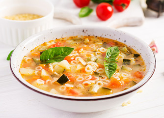 Minestrone, italian vegetable soup with pasta on white table. Vegan soup.