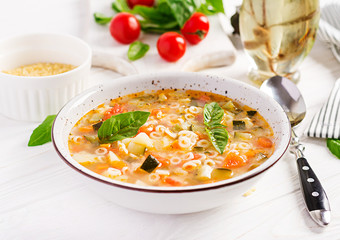 Minestrone, italian vegetable soup with pasta on white table. Vegan soup.