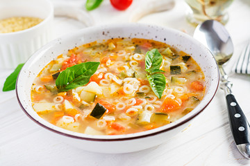 Minestrone, italian vegetable soup with pasta on white table. Vegan soup.