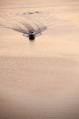 The motor boat floats on a flat sea surface
