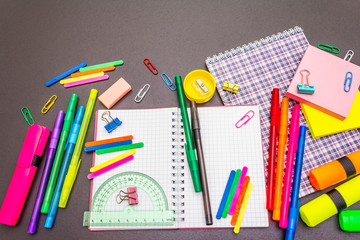 Back to school concept. School education supplies on black stone concrete background.