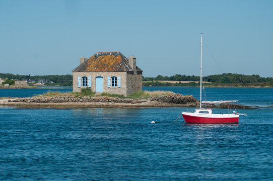 View of sailboat in front of the famous little stoned house in St cado island in brittany-  France