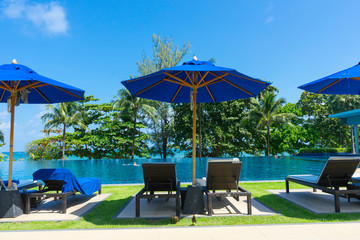 Daybed sun lounger chair by poolside with towel and umbrella