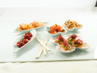 tapas y aperitivos frescos y saludables  en mesa de cristal, celebraciones. tapas and appetizers bell pepper stuffed with seafood, two trays.