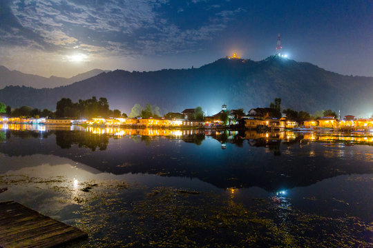 Dal lake (Golden lake) at Srinagar, India as seen on a full moon night with house boats lit up. Shankaracharya temple seen on top of the hills. Beautiful reflection on calm waters. Peaceful kashmir