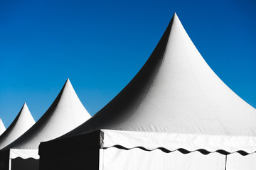 Pointed tents against the blue sky