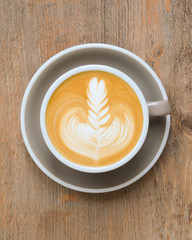 Cappuccino mit Latte Art auf einem Holztisch