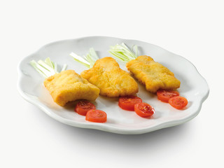 Pescado rebozado con tomates y puerro , comida niños sobre fondo blanco. Battered fish with tomatoes and leeks, children's meal on a white background.
