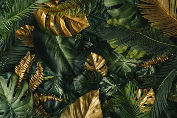 Creative nature background. Gold and green tropical palm leaves. Minimal summer abstract jungle or...
