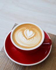 Cappuccino mit Latte Art auf einem weißen Tisch