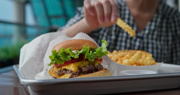 Woman eat burger in fast food restaurant