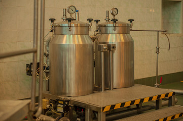 Equipment for preparation of beeer..Lines of metal tanks in modern brewery. Manufacturable process of brewage. Mode of beer production. Inside view of modern brewhouse with stainless barrels