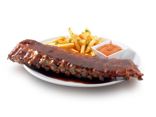 Costillar con patatas y salsa chimichurri. Ribs with potatoes and chimichurri sauce.