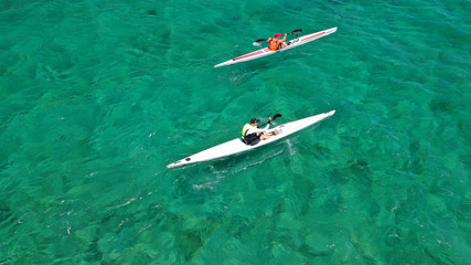 Obraz premium Aerial drone photo of fit men practising sport canoe in tropical open ocean bay with turquoise clear sea