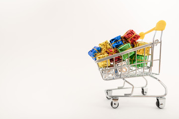 Christmas gifts in a supermarket trolley on white background. Online shopping concept - trolley full of gifts. Black Friday and Cyber Monday
