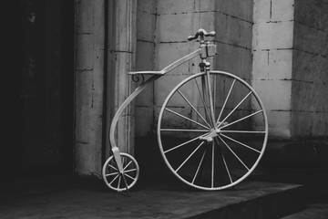white circus bike at the entrance to the hotel, white brick background, black and white photo © Марина Филатова