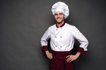 Young male chef isolated on a black background.