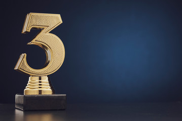 Isolated gold colored statue of number 3
