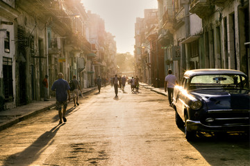 Cuban people in the street of Old Havana going to work with the first lights of the morning,...
