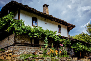 Colourful flowes outside traditional Bulgarian old house in rural village