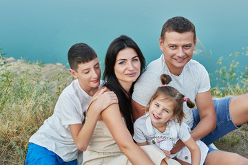 Family travel with children son and daughter on vacation near lake in summer. Tourist enjoying on vacation. Relax on lake. Summer vacation.  Camping, picnic near lake.Family on background of landscape