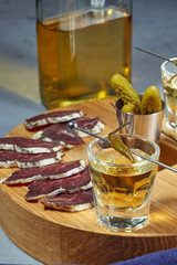 whiskey in two glasses and sliced jerky with spices on the oak surface. Close up.