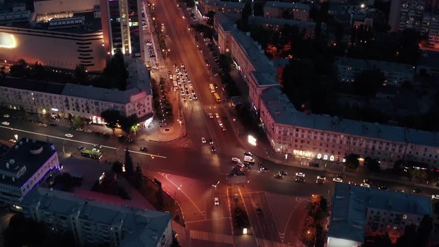 Road traffic and car accident on roads intersection in night European city midtown or center, drone footage from above, aerial view