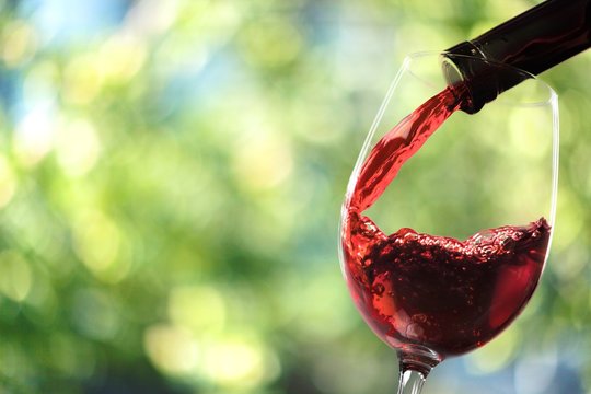 Red wine and glass on background