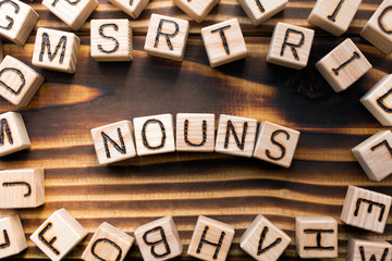 nouns composed of wooden cubes with letters, Part of speech concept scattered around the cubes...