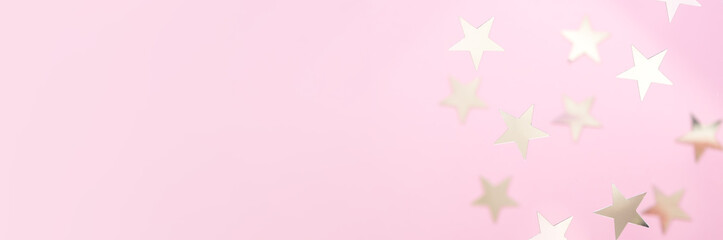Fototapeta na wymiar Silver glitter stars on a pink background. Falling confetti. Festive holiday pastel backdrop. Place for design.
