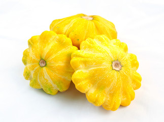 Three yellow bush pumpkins on a white background