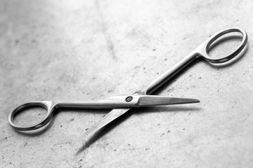 Old surgical scissors on a metal table, shallow depth of field.