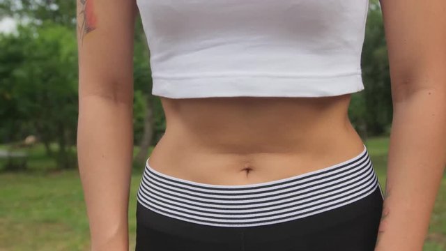 Flat belly girl during breathing exercises bodyflex. Belly close-up view.
