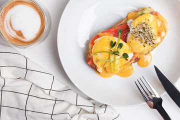 Delicious breakfast with poached eggs and hollandaise sauce on toast with smoked salmon