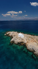 Aerial drone photo of small picturesque chapel of Agios Nikolaos built in small islet near picturesque main town of Hydra or Ydra island, Saronic gulf, Greece
