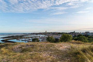 View from the dunes on the harbor of Terschelling with the lighthouse Brandaris. The Netherlands, Europe.